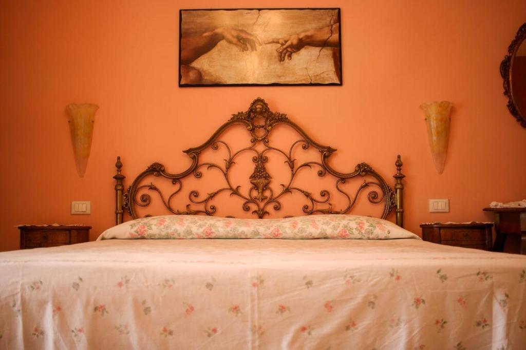 1 cama con cabecero ornamentado en un dormitorio en La casa di Catia, en Florencia