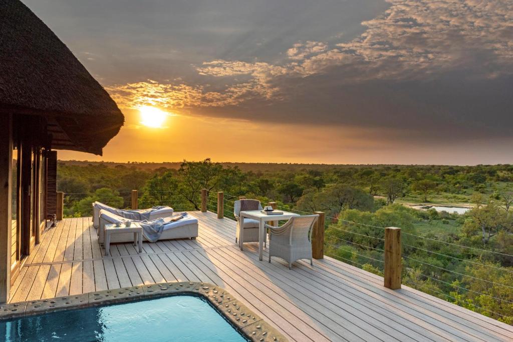 a deck with a pool and a table and chairs at Leopard Hills Private Game Reserve in Sabi Sand Game Reserve