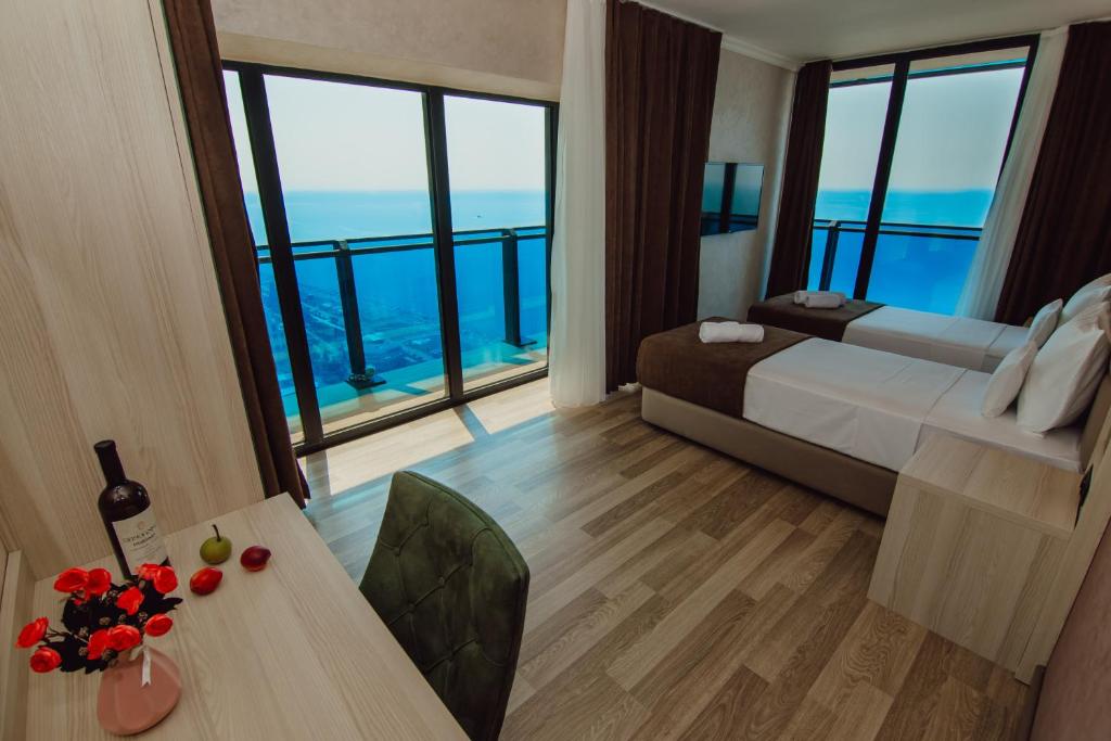 a hotel room with a bed and a table with flowers on it at Hotel Kanzler in Batumi
