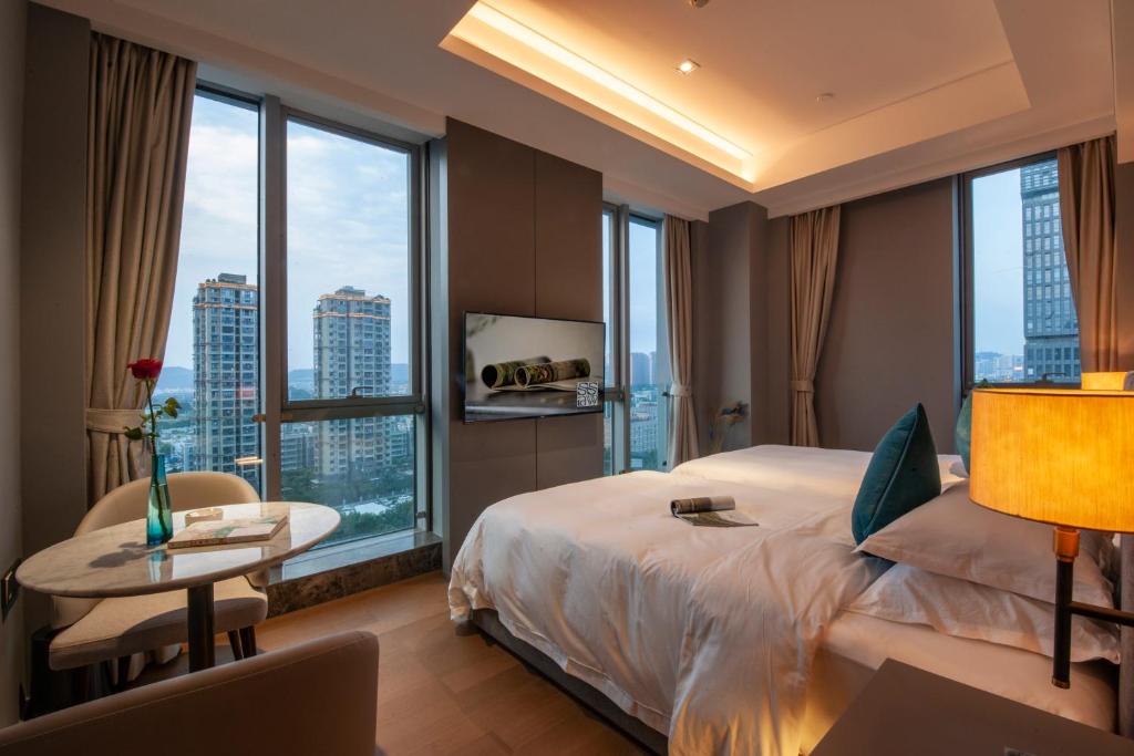 um quarto de hotel com uma cama grande e uma mesa com uma mesa em SSAW Boutique Hotel Wenzhou Dexin em Wenzhou