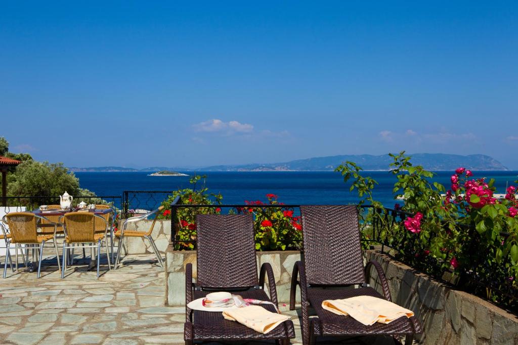 a group of chairs and tables with a view of the ocean at Hovolo Hotel Apartments in Neo Klima