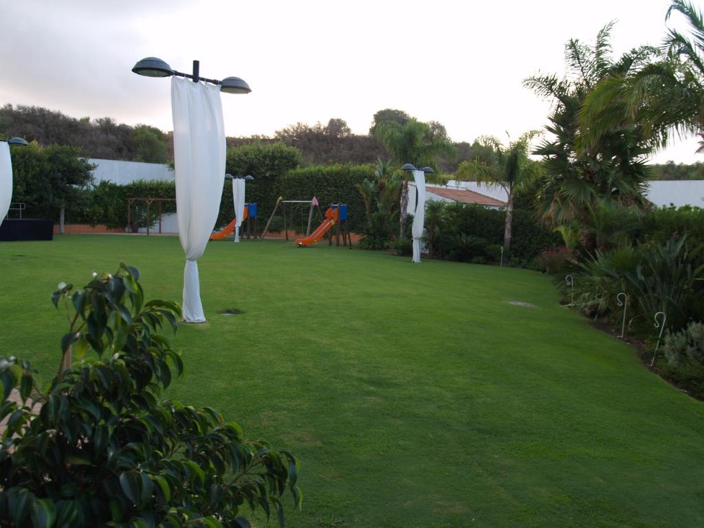 a yard with a playground with white swings at Hotel Montera Plaza in Los Barrios