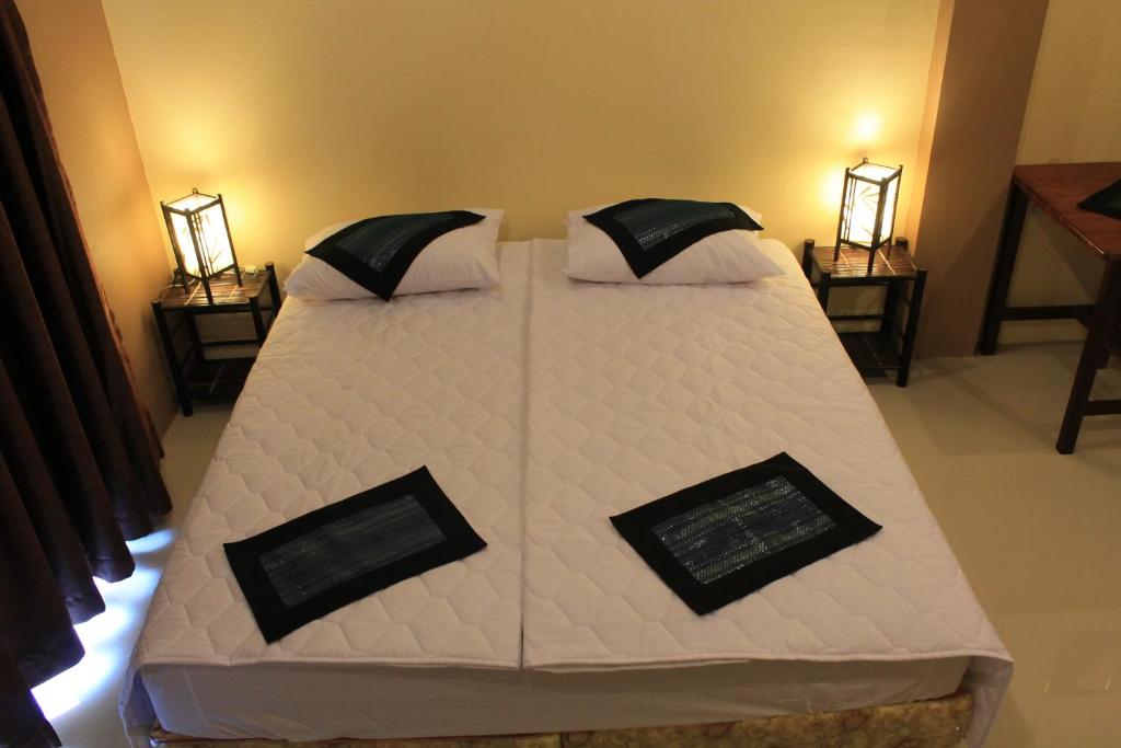 a large bed in a room with two lamps at Avalon Residence in Savannakhet