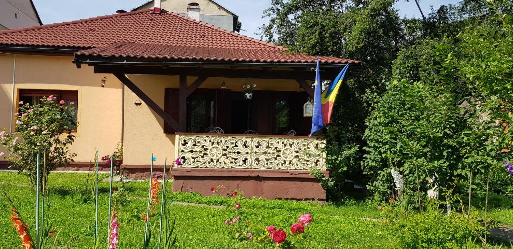 a house with a fence and a flag in the yard at La Mihai in Lupeni