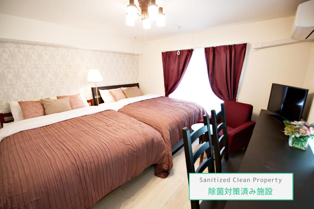 1 dormitorio con 2 camas, TV y silla en Prime Stage Otsuka/Ikebukuro P204 en Tokio