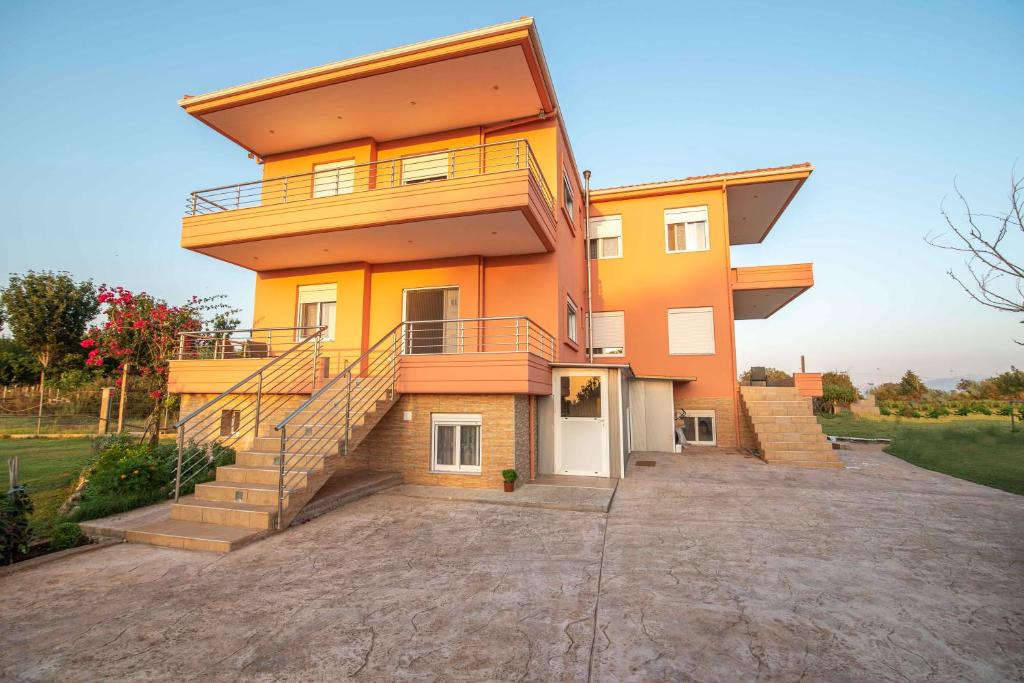 a large orange house with stairs and a driveway at Kassianis House Mytikas in Kalamitsi