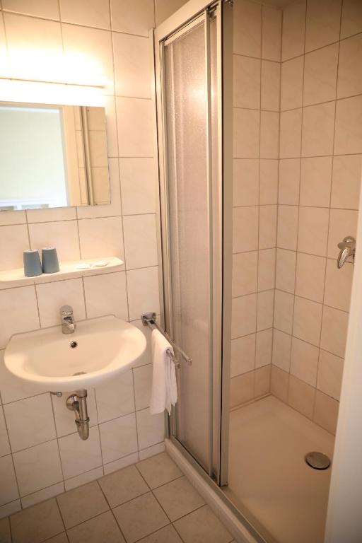 a bathroom with a sink and a shower at Pension Elfmeter in Rheinsberg