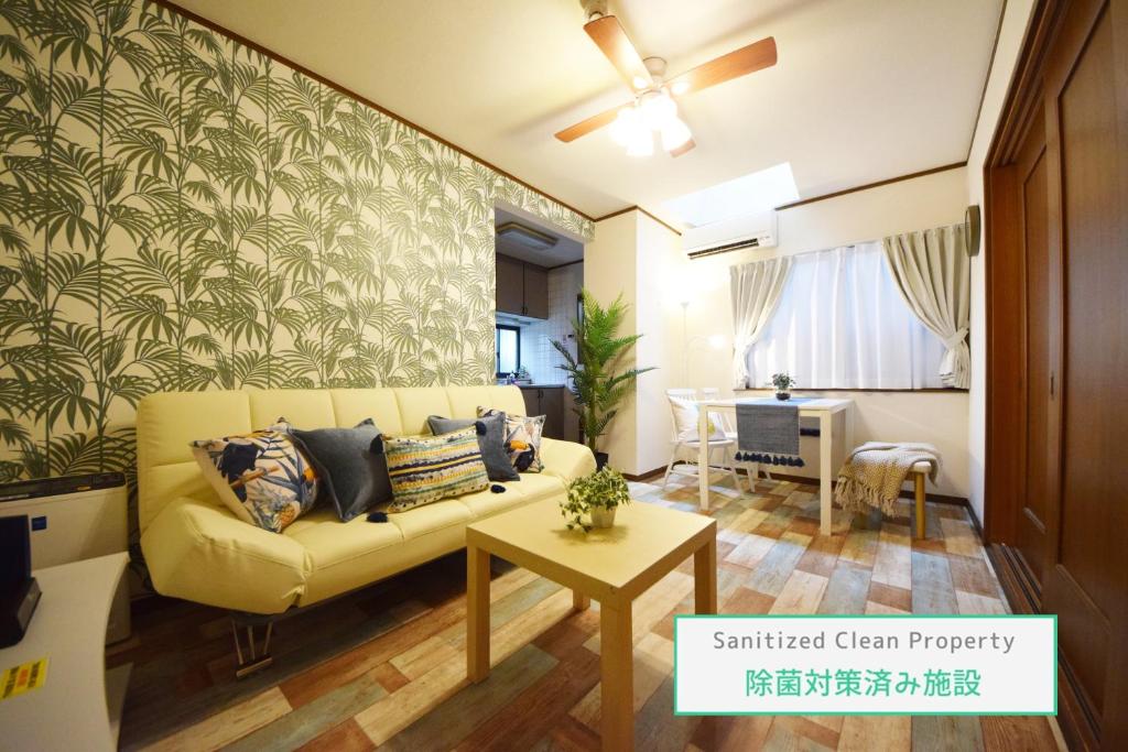 - un salon avec un canapé jaune et une table dans l'établissement The Nest Ikebukuro House, à Tokyo