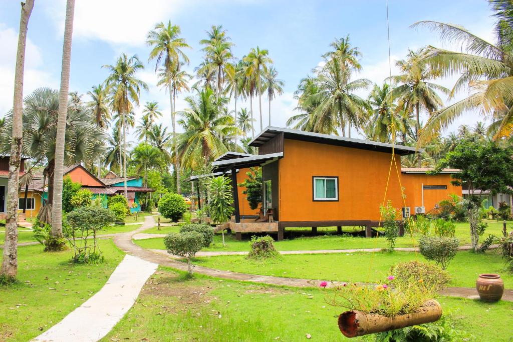 a house in the middle of a yard with palm trees at Koh Kood Far East Resort in Ko Kood