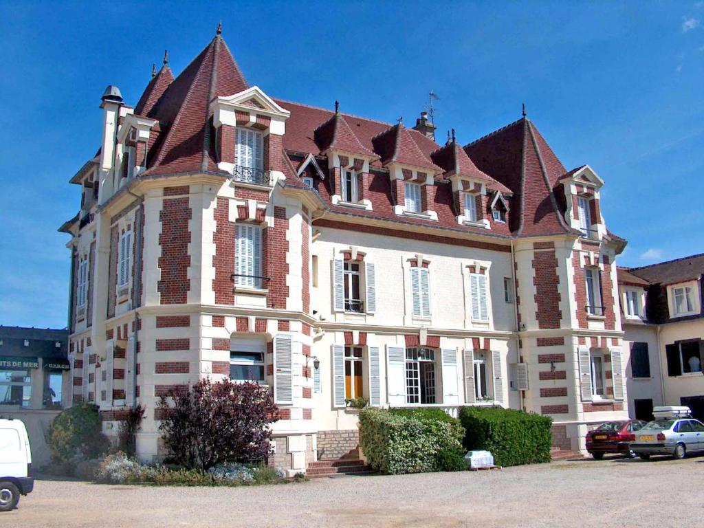 un grand bâtiment en briques avec un grand toit dans l'établissement Apartment Le Caneton-3 by Interhome, à Cabourg