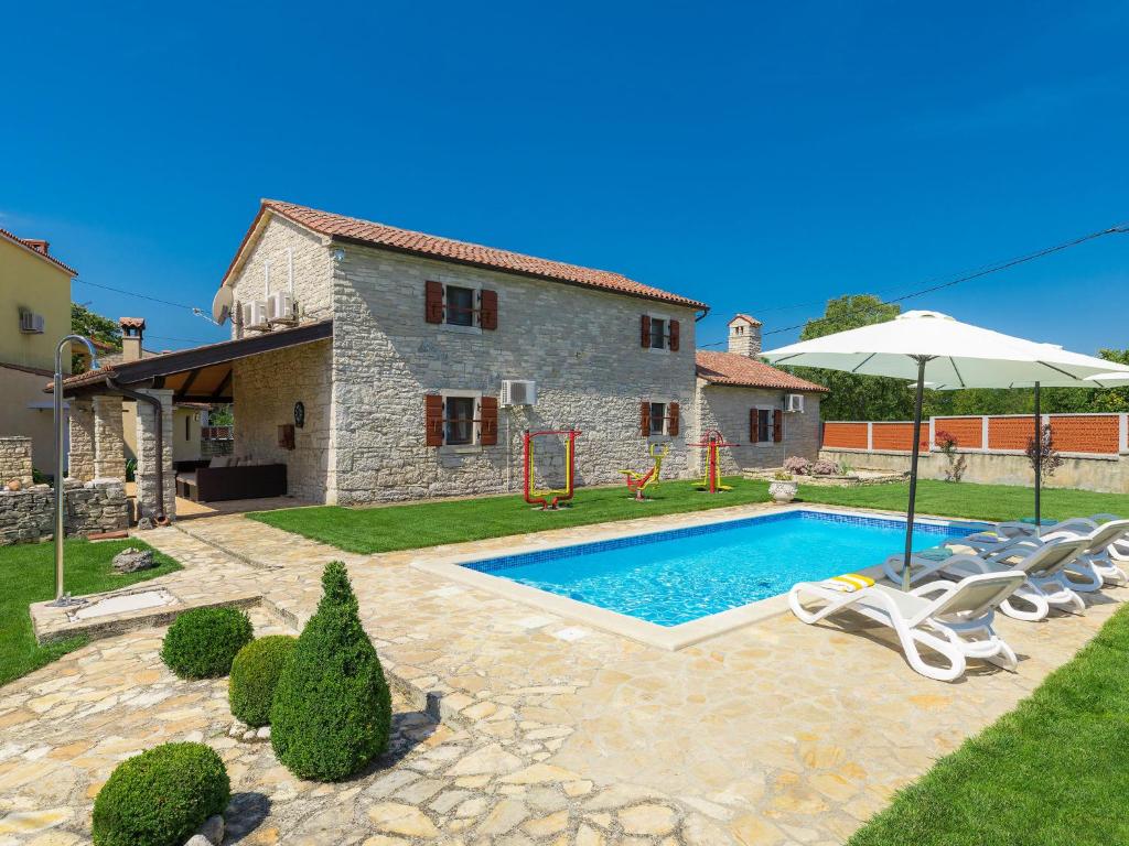 a villa with a swimming pool in front of a house at Holiday Home Bozac - ROJ417 by Interhome in Žminj