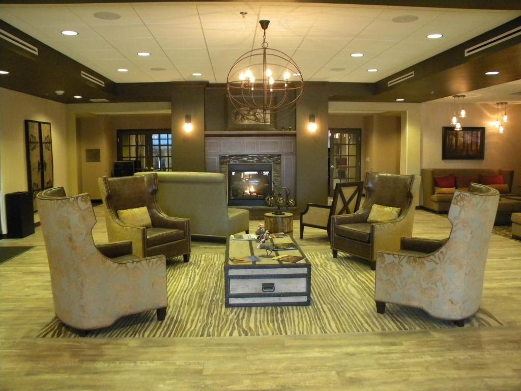 a living room with chairs and a fireplace at Teddy's Residential Suites Watford City in Watford City