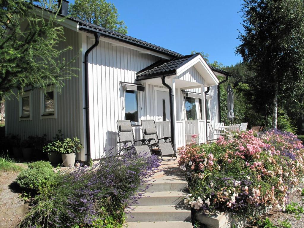 a house with chairs and flowers in front of it at Chalet Norrkrog Utsikten by Interhome in Norrkrog