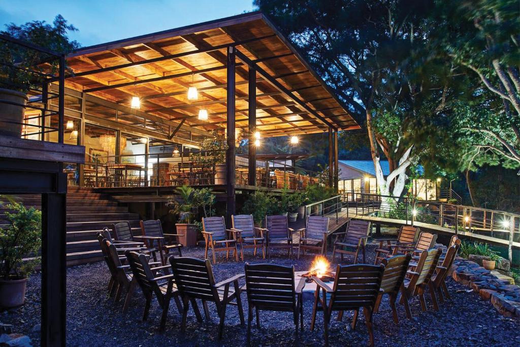a patio with chairs and a fire in front of a building at Fugitives Drift Lodge in Rorkeʼs Drift