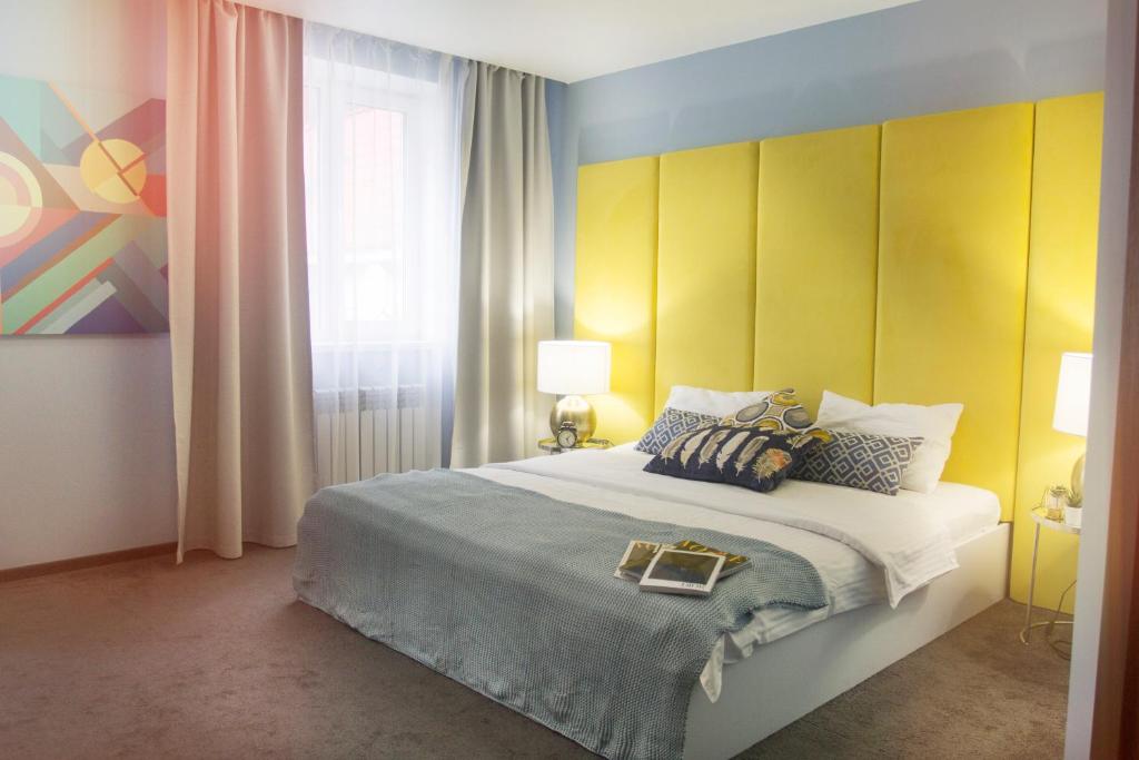 Aramil'にあるМаксим Парк Отельのベッドルーム1室(大型ベッド1台、黄色のヘッドボード付)