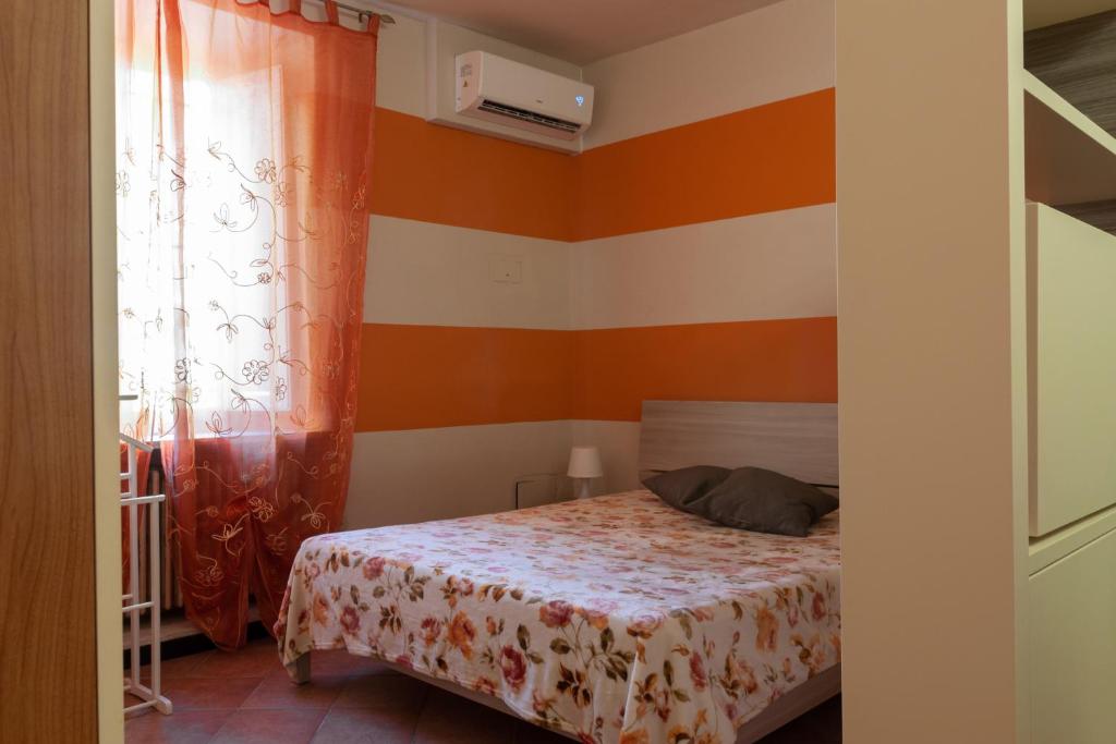 a bedroom with a bed and orange and white stripes at Casa Nocchi in Lucca