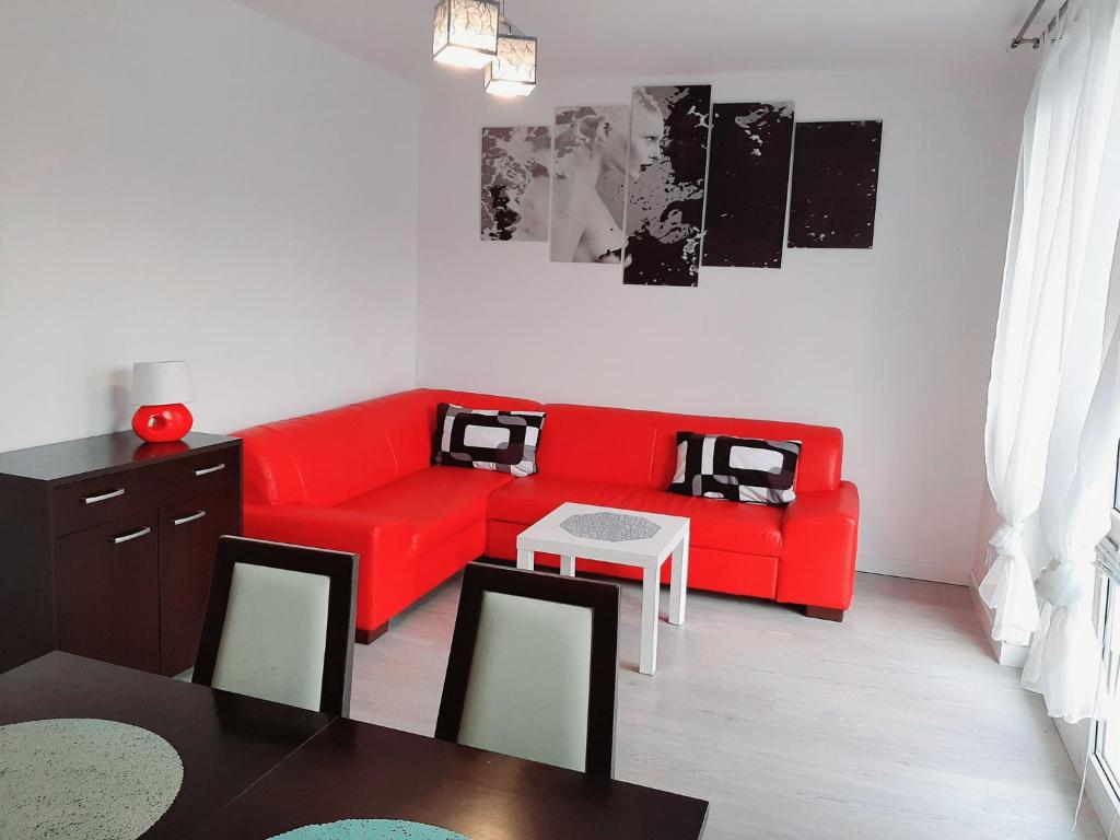 斯維諾烏伊希切的住宿－Apartament Baltis Świnoujście，客厅配有红色的沙发和桌子