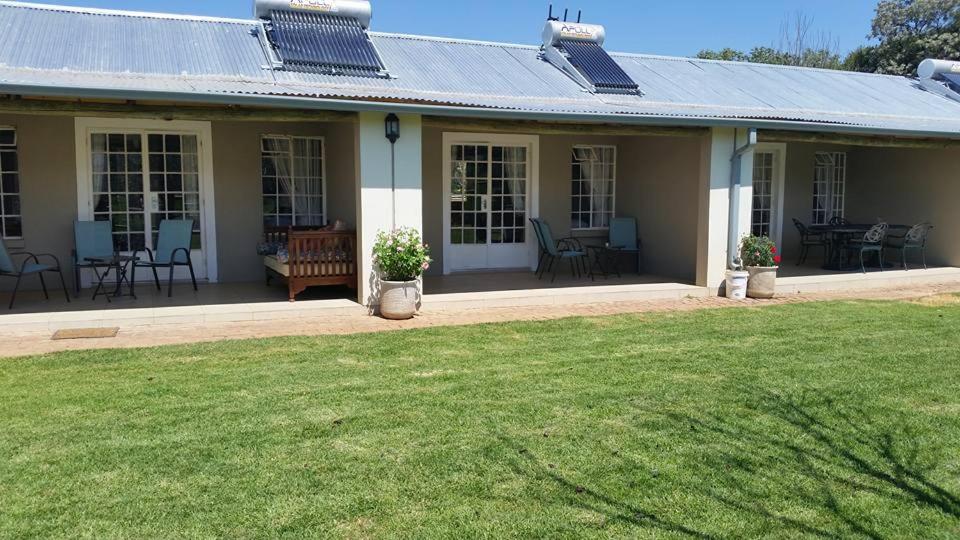 a house with a lawn in front of it at Green Willows Guest House in Skeerpoort