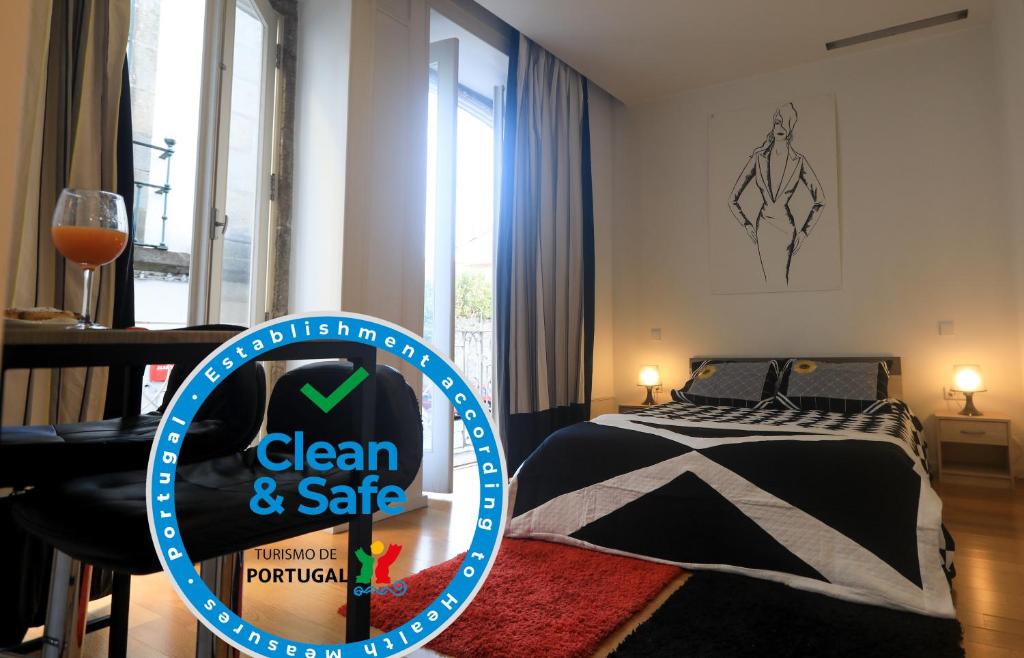 ギマランイスにあるTM Guest Houseのベッド1台、清潔で安全なサインが備わる客室です。