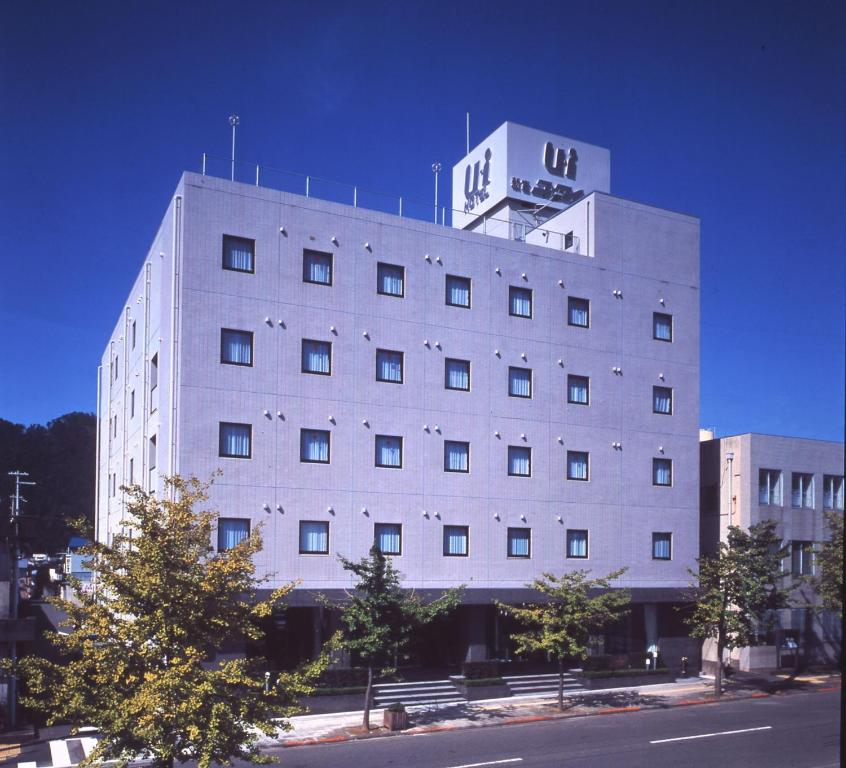 a large white building with a clock tower on top at Shingu UI Hotel in Shingū