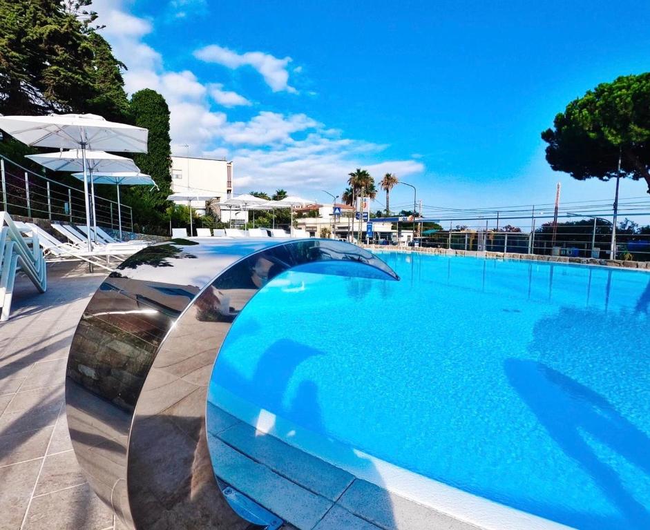 una piscina azul con un puente sobre ella en Hotel Napoleon, en San Remo