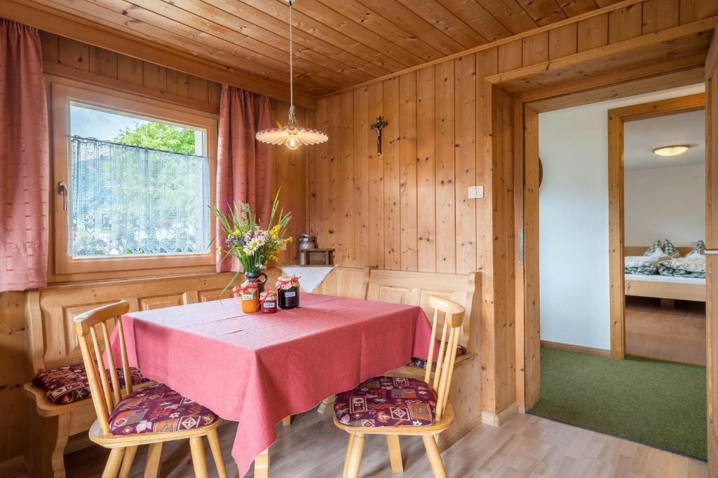 une salle à manger avec une table et des chaises roses dans l'établissement Jogglanderhof - Hochwilde, à Moso in Passiria