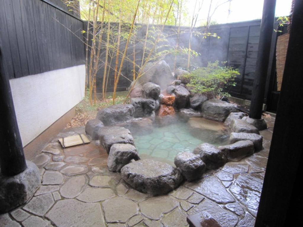un jardín con un estanque con una boca de incendios en Ryokan Mikasaya, en Beppu