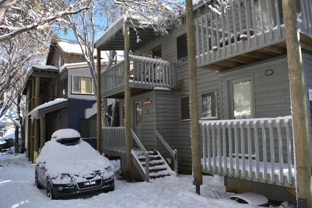 pokryty śniegiem dom z samochodem zaparkowanym przed nim w obiekcie Drovers Rest w mieście Dinner Plain