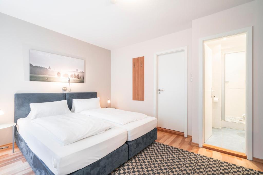 1 dormitorio con 1 cama grande con sábanas blancas en Flatista Boutique Hotel - Self Check-in en Múnich