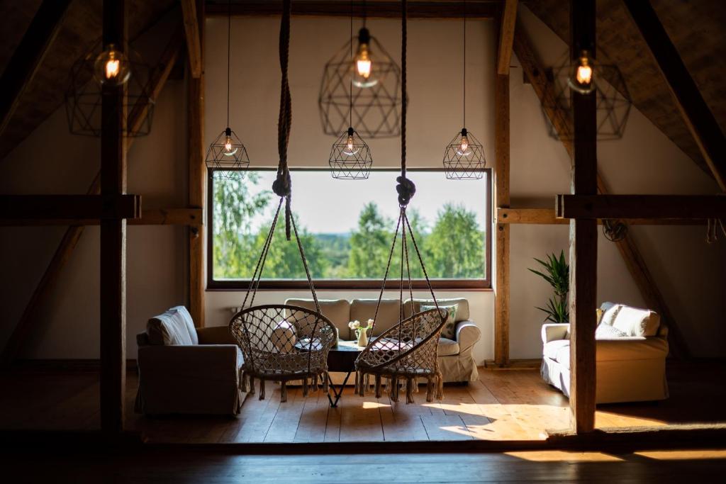 een woonkamer met een bank, een tafel en stoelen bij Siedlisko Szymonka in Ryn