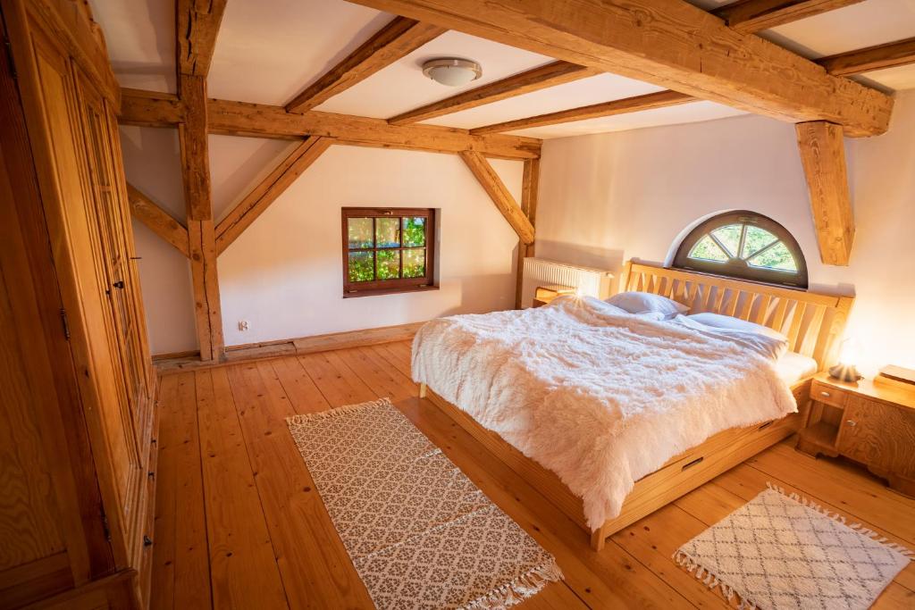 ein Schlafzimmer mit einem Bett in einem Zimmer mit Holzböden in der Unterkunft Siedlisko Szymonka in Ryn