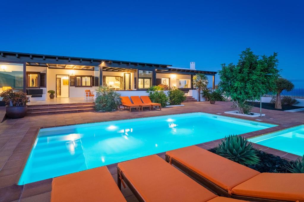 a swimming pool in front of a house at Villa Agave // Villa Cardón in Puerto Calero