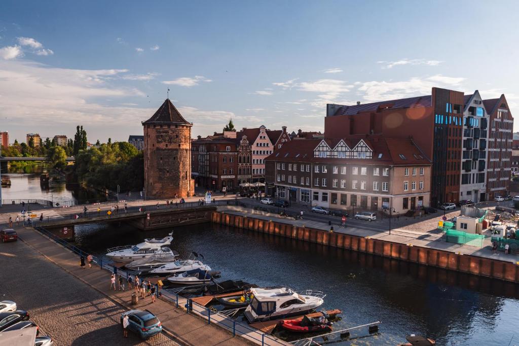 a city with boats docked in a river with buildings at Apartament Amber Centrum z basenem in Gdańsk