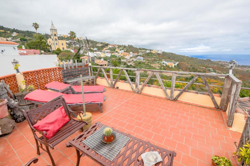 a patio with chairs and a table on a balcony at Casa Carmela in La Guancha