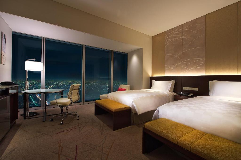 a hotel room with two beds and a desk at Osaka Marriott Miyako Hotel in Osaka