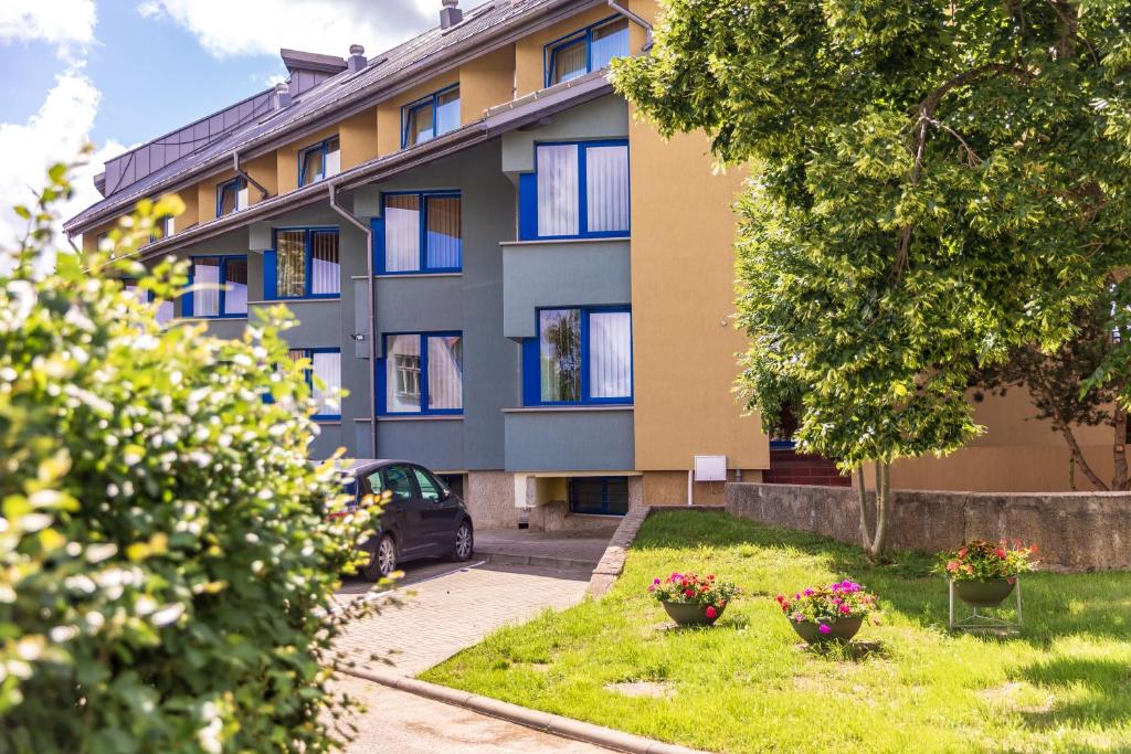 a building with a car parked in front of it at Apartamentai "Tenisas" in Palanga