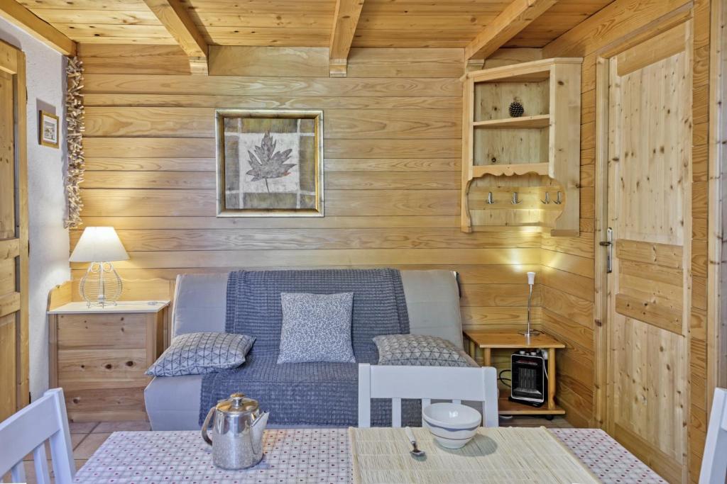 uma pequena sala de estar com um sofá e uma mesa em Appartement privatif type chalet cosy et calme em Métabief