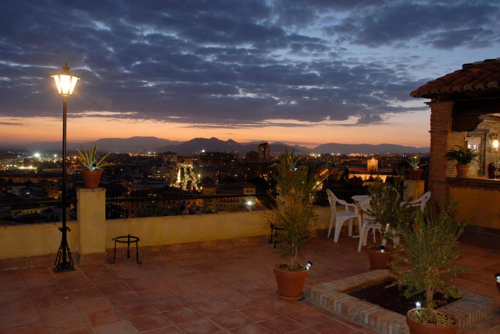 uma varanda com vista para a cidade à noite em Carmen en el Albaicín con Jardin y Vistas em Granada
