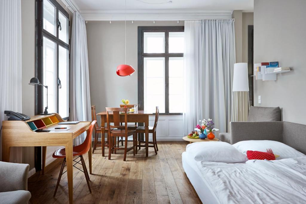 a hotel room with a bed and a dining room at Wedina Serviced Apartments in Hamburg
