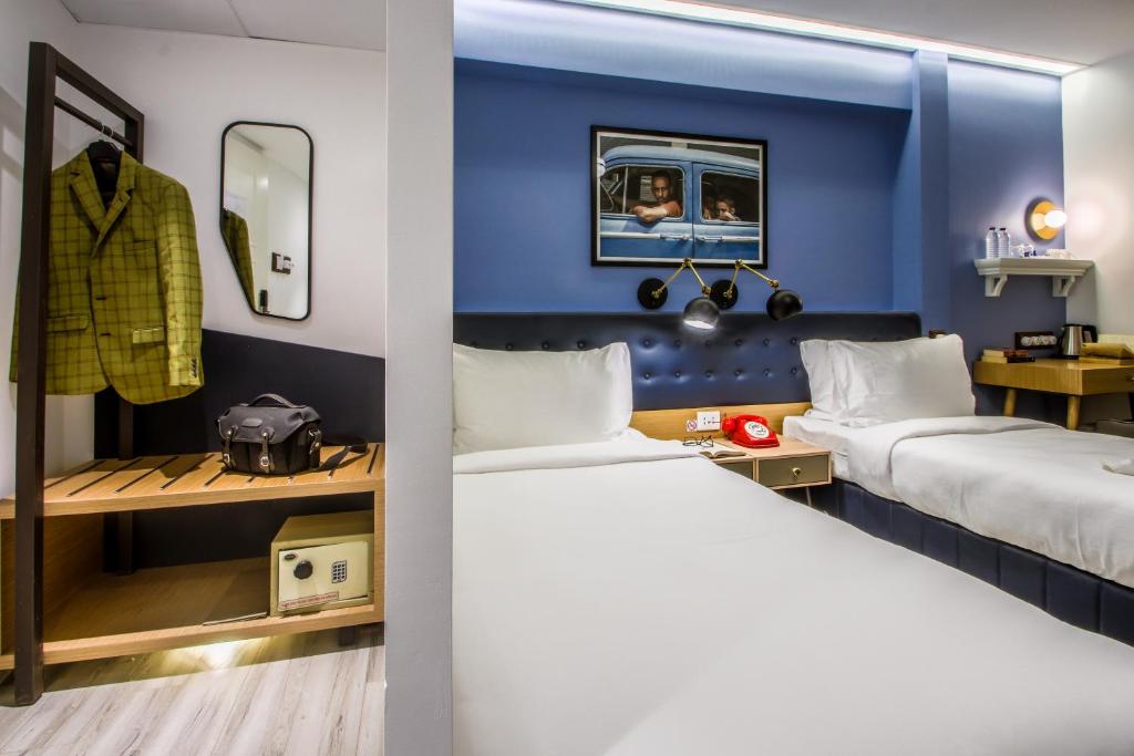 a bedroom with two beds and a blue wall at T24 Retro in Mumbai