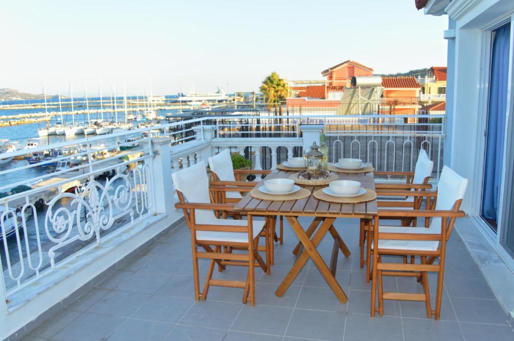 een tafel en stoelen op een balkon met uitzicht bij La Maison Bleue in Lixouri