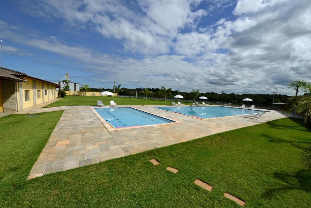 a swimming pool in the middle of a yard at Pousada Haras Santa Rita in Poconé
