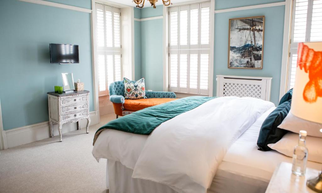 a bedroom with blue walls and a bed and a chair at Moore House in Hastings