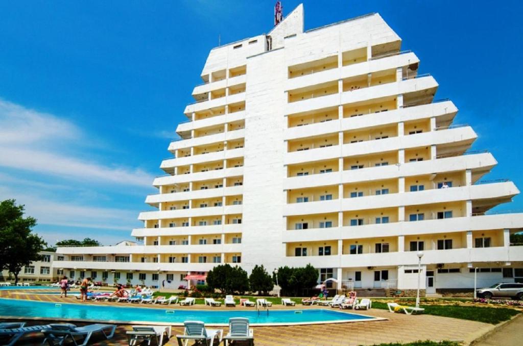 un gran edificio blanco con una piscina frente a él en Malaya Bukhta Health Resort en Anapa