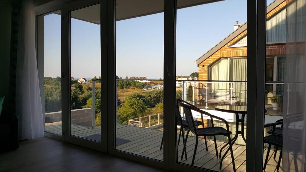 a view from the balcony of a house with sliding glass doors at Morskie Wzgórze Apartamenty in Mechelinki