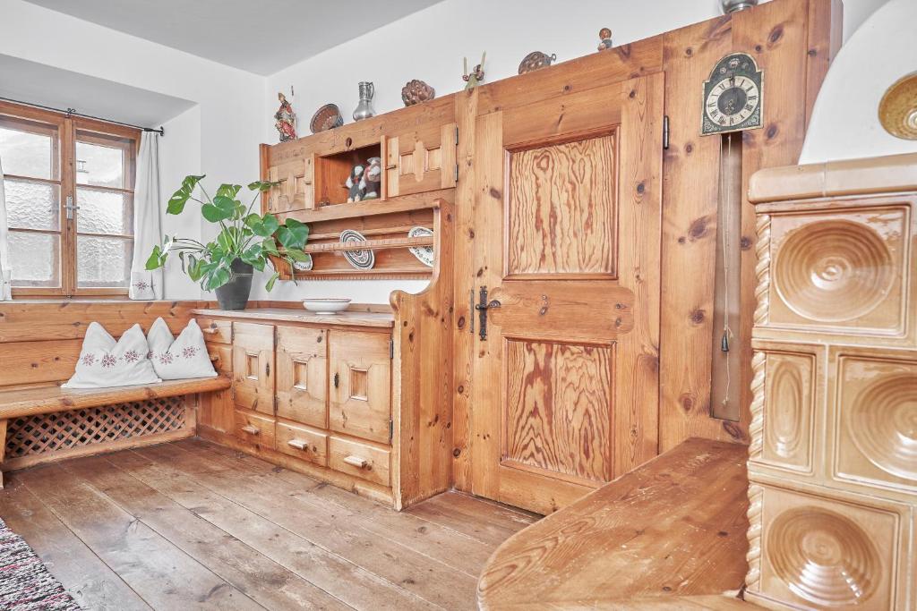 a kitchen with wooden cabinets and a wooden door at Marbergerhaus Umhausen in Umhausen