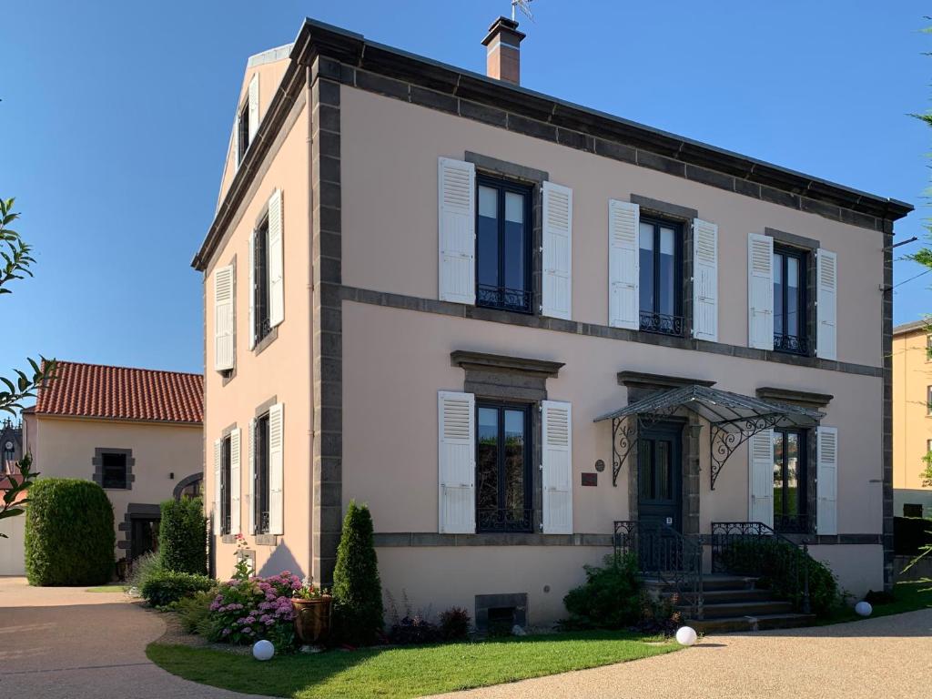 een wit huis met zwarte ramen en deuren bij L'Enclos de Ribains in Aubière