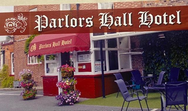 布里奇諾斯的住宿－Parlors Hall Hotel，餐厅前面摆放着椅子和鲜花