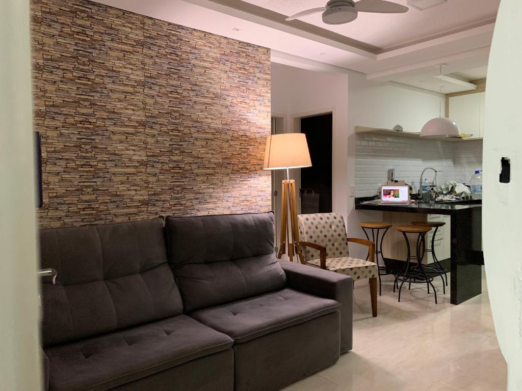 a living room with a couch and a brick wall at APARTMENTFORSTAY 18 Tânger in Marília
