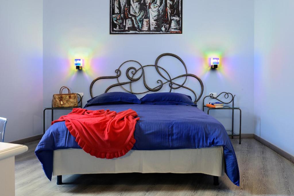 a bedroom with a blue and red bed with two lamps at SmArt Hotel Bartolini in Montecatini Terme